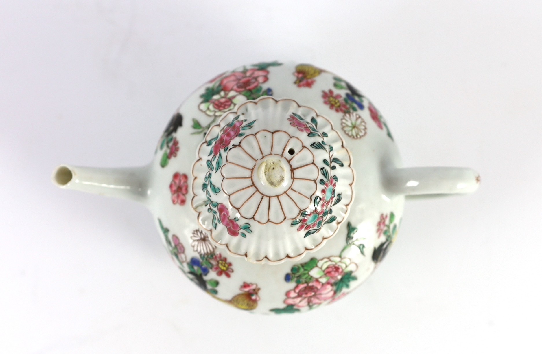 A Chinese famille rose chrysanthemum moulded teapot, early Qianlong period, painted with a cockerel amongst flowers, on a cage work base, 10 cms high